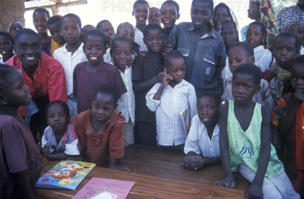 In a World Vision project, friends and neighbors have gathered on the occasion of a godfather's visit, Nyabubinza, Tanzania, Africa, June 2000, vintage, retro, old, historic