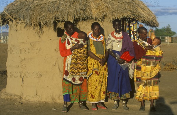 Maasai woman with babies in front of a clay hut near Arusha, Tanzania, Africa, June 2000, vintage, retro, old, historic