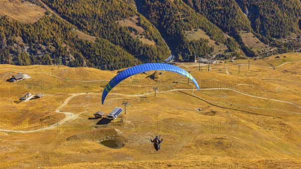 A paraglider takes off from the summit of Corne de Sorebois, Val d'Anniviers, Valais Alps, Canton of Valais, Switzerland
