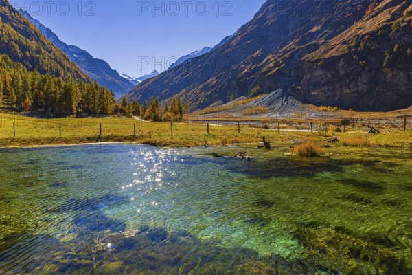 Small pond and alpine meadow in autumn colors, near Zinal, Val d'Anniviers, Valais Alps, Canton of Valais, Switzerland
