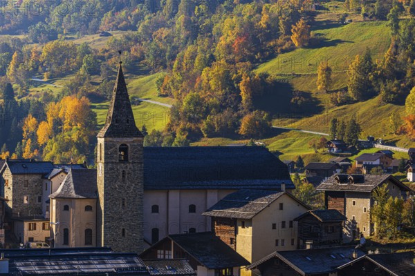 The church of Sainte-Euphemie in Vissoie, in the back a mountain landscape in autumn colors, Val d'Anniviers, Valais Alps, Canton of Valais, Switzerland