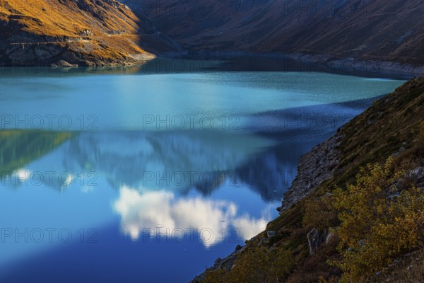 Clouds are reflected in the turquoise Lac de Moiry Reservoir, Val d'Anniviers, Valais Alps, Canton of Valais, Switzerland