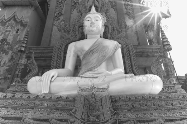 Buddha statue with tunic, Bhumispara mudra, Buddha Gautama at the moment of enlightenment, at the entrance to Wat Sitthawararam, Bangkok, Thailand
