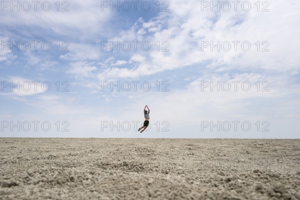 Symbolic picture, abstract, man jumping on the Etosha pan, salt pan, Etosha National Park, Namibia