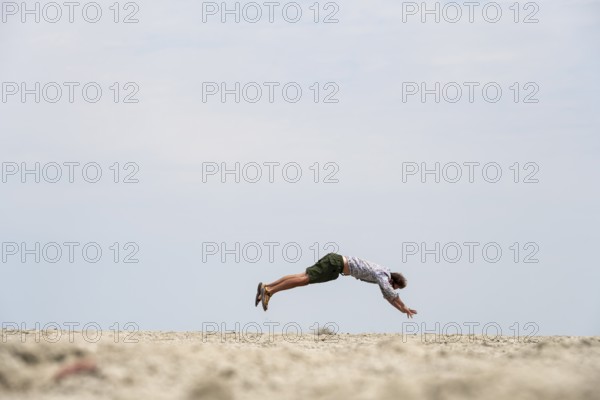Abstract, man jumping horizontally at the Etosha pan, salt pan, Etosha National Park, Namibia