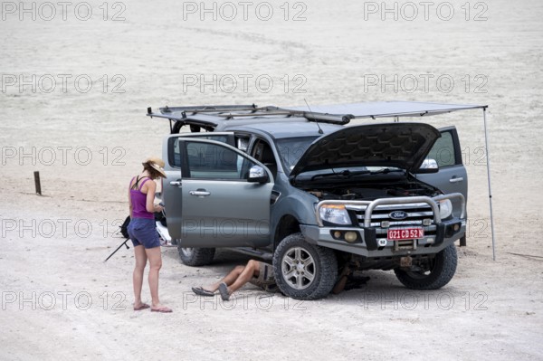 Symbolic picture, car breakdown, man repairing car, Etosha pan, Etosha National Park, Namibia