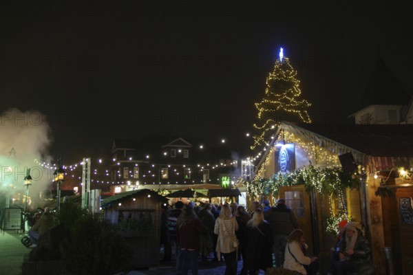A festive Christmas market at night with glowing lights and a decorated Christmas tree, Winterberg, North Rhine-Westphalia, Germany