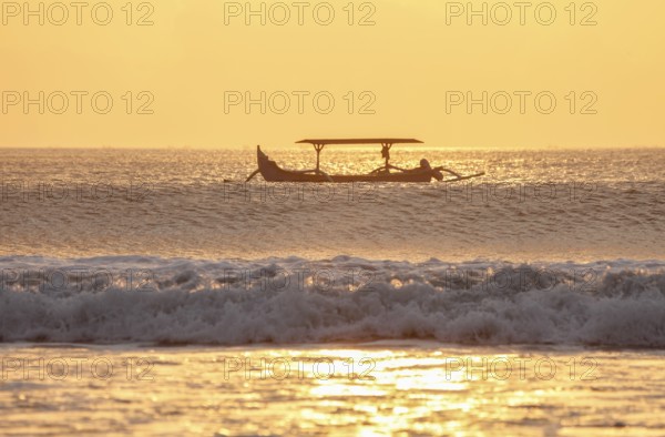 IOutrigger fishing boat at sunset on Kuta Beach, Bali, Indonesia