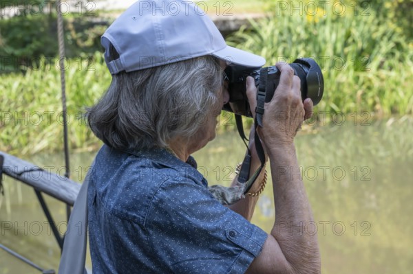 Elderly woman taking pictures, Amberg Upper Palatinate, Bavaria, Germany