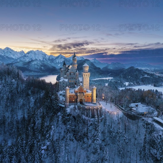 Snowy Neuschwanstein Castle surrounded by alpine mountains at dusk, Schwangau near Füssen, Ostallgäu, Allgäu, Bavaria, Germany