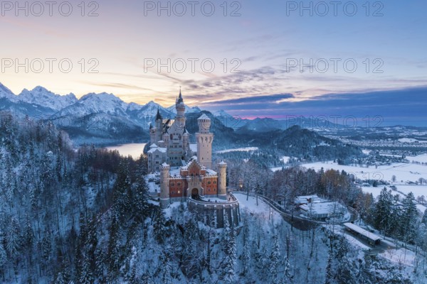 Neuschwanstein Castle in winter at sunset with snow-covered mountains and peaceful atmosphere, Schwangau near Füssen, Ostallgäu, Allgäu, Bavaria, Germany