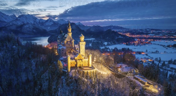 Panoramic view of Neuschwanstein Castle in snowy mountain landscape at dusk, night view, Schwangau near Füssen, Ostallgäu, Allgäu, Bavaria, Germany