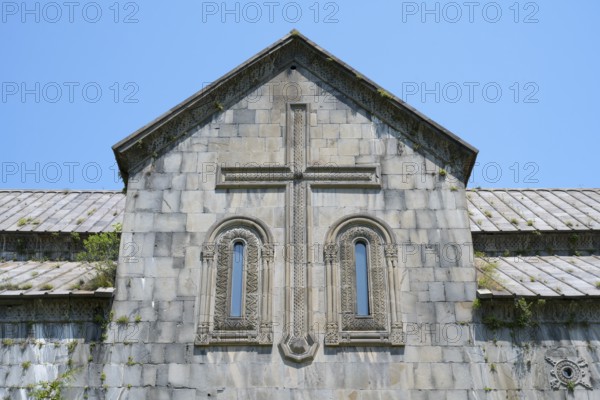 Historic church façade with stone cross and windows under a blue sky, Akhtala monastery, Akhtala town, Lorikeet province, Armenia