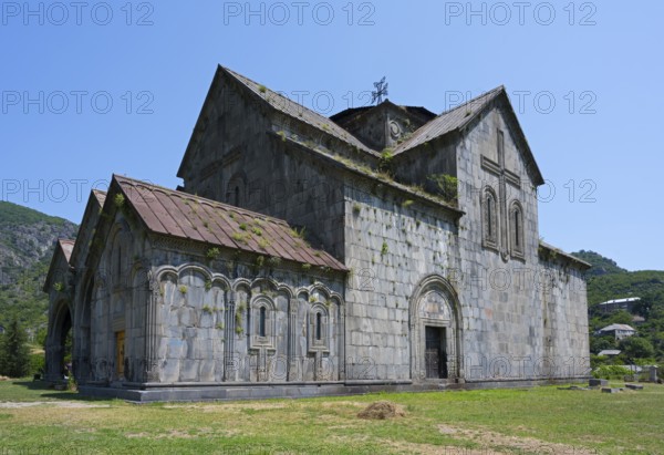 Historic stone church in rural area under blue sky, Romanesque style, Akhtala monastery, Akhtala town, Lorikeet province, Armenia