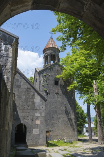 View through an arch of a church with bell tower, surrounded by trees, in shade, Sanahin monastery, Sanahin village, UNESCO World Heritage Site, Lorikeet province, Armenia