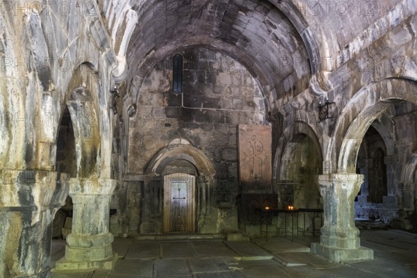 Dark, antique stone hall with arches flanked by glowing candles, Sanahin monastery, Sanahin town, UNESCO World Heritage Site, Lorikeet province, Armenia
