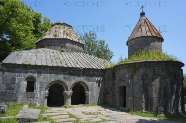 Historic monastery with two domes, overgrown roofs and stone structures under clear skies, Sanahin monastery, town of Sanahin, UNESCO World Heritage Site, Lorikeet province, Armenia