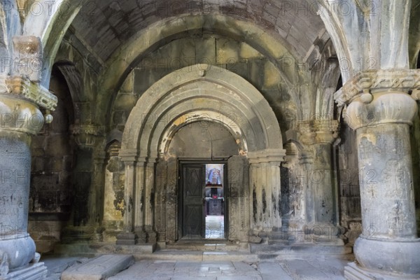 Ancient building entrance with stone arches and a central wooden door, Sanahin monastery, Sanahin town, UNESCO World Heritage Site, Lorikeet province, Armenia