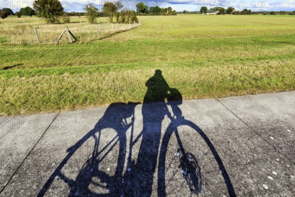 Cyclist, bike tour, Elbe cycle path, Elbe dike, shadow casting, Neuhaus district, Lower Saxony Elbe floodplain, Germany