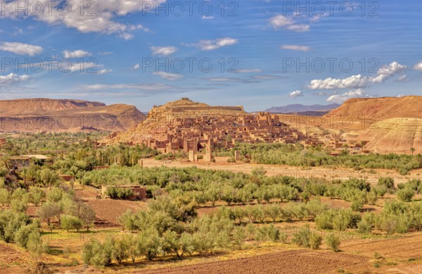 Historic clay buildings in an oasis surrounded by desert landscape, Morocco, Ait Ben Haddou, panorama
