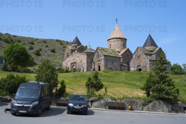 Historic monastery with stone buildings in a mountainous landscape with bright blue sky, Goshavank monastery, Tavush province, Armenia