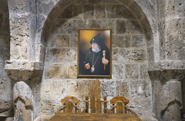 Interior view with painting of a religious motif in front of a stone wall and wooden furniture, refectory interior, dining room, Haghartsin monastery, Hagarzin, Tavush province, Armenia
