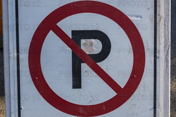 Close-up of posted white, red and black No Parking pictogram notice sign outdoors, Quebec, Canada