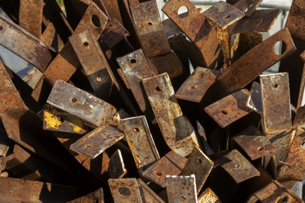 Close-up of pile of old rusted steel support brackets with bored holes, Quebec, Canada