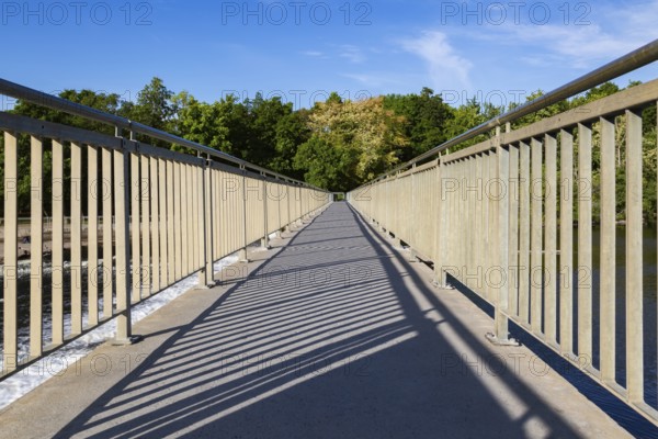 Wide angle view of pedestrian walkway on top of water flow control Moulin Neuf dam over Des Mille-Iles river in summer, Old Terrebonne, Quebec, Canada