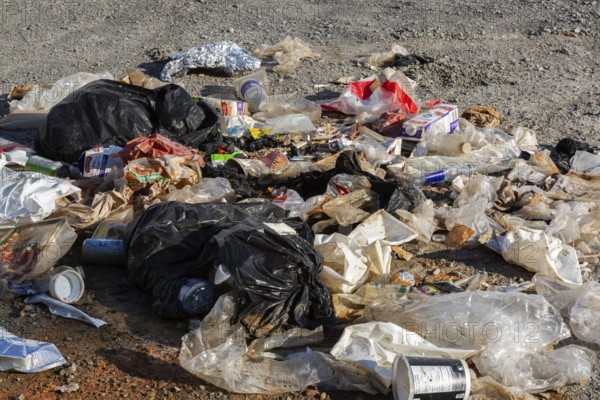 Recyclable plastic, paper and cardboard items discarded on the ground in public park, Quebec, Canada