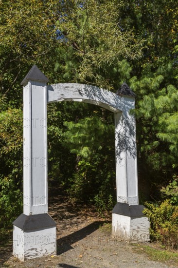 White painted wooden portal gate at start of hiking trail in public nature park in late summer, Parc du Grand-Coteau, Mascouche, Quebec, Canada