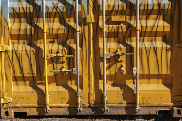 Close-up of locked doors on yellow painted metal boxed shaped shipping container, Quebec, Canada