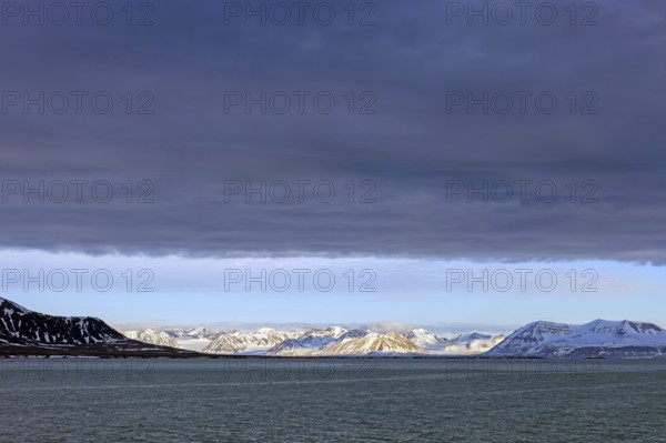 Snow covered mountains and glaciers debouching into Lilliehöökfjorden, fjord branch of Krossfjorden in Albert I Land, Spitsbergen / Svalbard, Norway