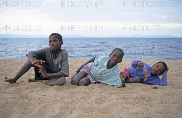 Three local boys posing for the camera on the beach, Chitimba, Lake Malawi, Africa, July 2000, vintage, retro, old, historic