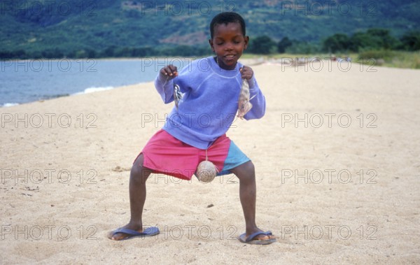 Little boy posing with caught fish for camera, Chitimba, Lake Malawi, Africa, July 2000, vintage, retro, old, historic