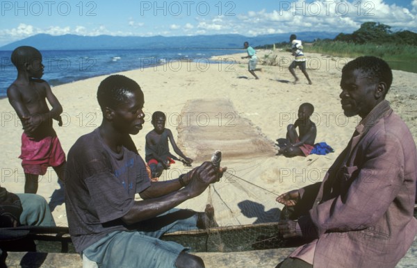 Fishermen at Kande Beach on Lake Malawi repair their nets, Malawi, Africa, July 2000, vintage, retro, old, historic