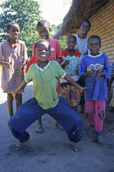 Local children dance happily to music in a village near Kande, Lake Malawi, Malawi, Africa, July 2000, vintage, retro, old, historic
