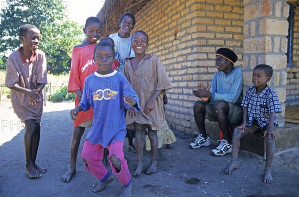 Local children dance happily to music in a village near Kande, Lake Malawi, Malawi, Africa, July 2000, vintage, retro, old, historic