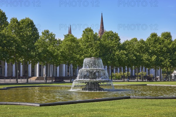 Green area, lawn, bowling green, trees, Platanus × acerifolia (Platanus ×hispanica), cascade fountain, historic building, colonnades, theatre colonnades, steeple of the market church, blue sky, cloudless, Kurhausplatz, Christian-Zais-Straße, Wiesbaden, state capital, independent city, Hesse, Germany