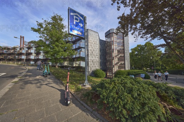 Theatre car park, modern architecture, sidewalk, e-scooter, traffic sign parking garage, trees, bushes, lawn, pedestrians as accessories, blue sky, cumulus clouds, evening light, Parkstraße and Paulinenstraße roads, Wiesbaden, state capital, district-free city, Hesse, Germany