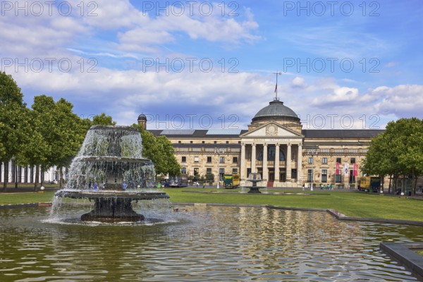 Spa hotel, neo-classical style, architect Friedrich von Thiersch, columns, gardens, trees, lawn, bowling green, abstract reflections on the water surface, blue sky, cumulus clouds, Kurhausplatz square, Wiesbaden, state capital, district-free city, Hesse, Germany