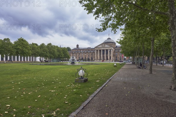 Casino, spa hotel, fountain, green spaces, trees, Platanus × acerifolia (Platanus ×hispanica), lantern, lawn, paths, cloudy, nimbostratus clouds, bowling green, Kurhausplatz, Wiesbaden, state capital, independent city, Hesse, Germany
