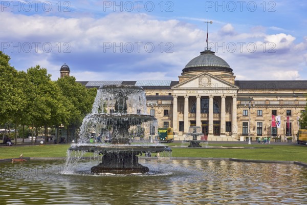 Spa hotel, neo-classical style, architect Friedrich von Thiersch, Aquis Mattiacis inscription, columns, gardens, trees, lawn, bowling green, abstract reflections on the water surface, blue sky, cumulus clouds, Kurhausplatz, Wiesbaden, state capital, district-free city, Hesse, Germany