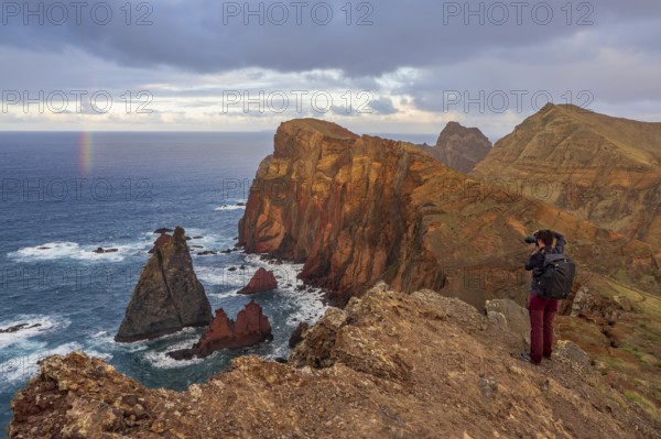 Photographer taking pictures on cliffs, rainbows over sea, volcanic peninsula, Ponta de São Lourenço, Ponta de Sao Lourenco, rocky coast, Punta de San Lorenzo, Madeira, Portugal