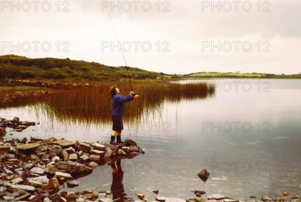 Woman fly fishing on Lough Sessiagh Lake, Portnablagh, County Donegal, Ireland 1960s