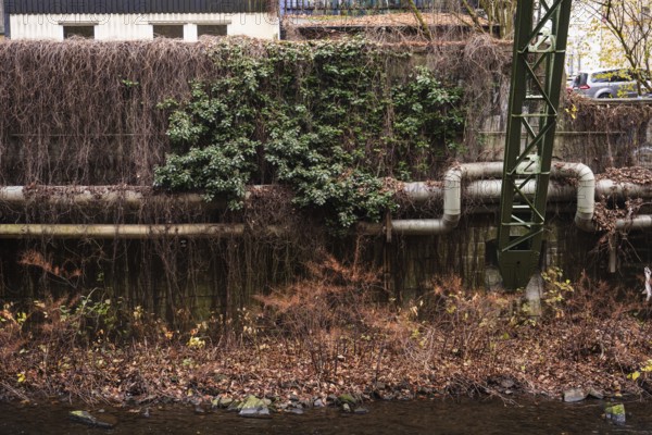 District heating pipeline in front of old industrial buildings on the banks of the Wupper, Wuppertal, Germany