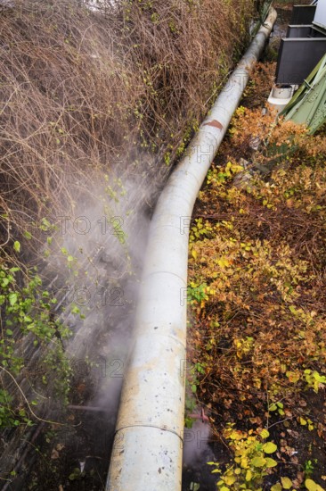 District heating pipeline in front of old industrial buildings on the banks of the Wupper, Wuppertal, Germany