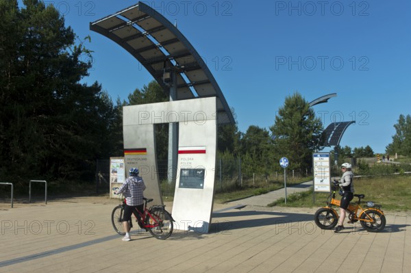 Cyclists at the symbolic gate on the border between Germany and Poland on the Europa Promenade, Ahlbeck, Usedom island, Mecklenburg-Western Pomerania, Germany