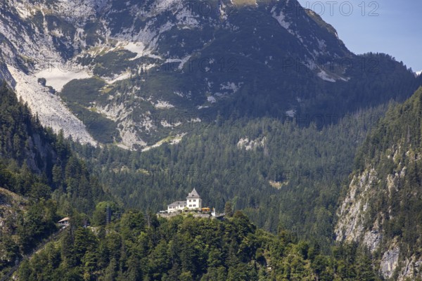 A, Hallstatt, A majestic castle perched high on a wooded mountain peak, Austria