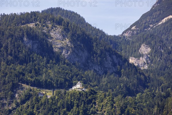 A, Hallstatt, A castle on a wooded mountainside surrounded by towering peaks, Austria